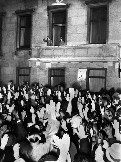Adolf Hitler and Joseph Goebbels salute the crowd from the balcony of Berlin's chancellery after the plebiscite for Austria